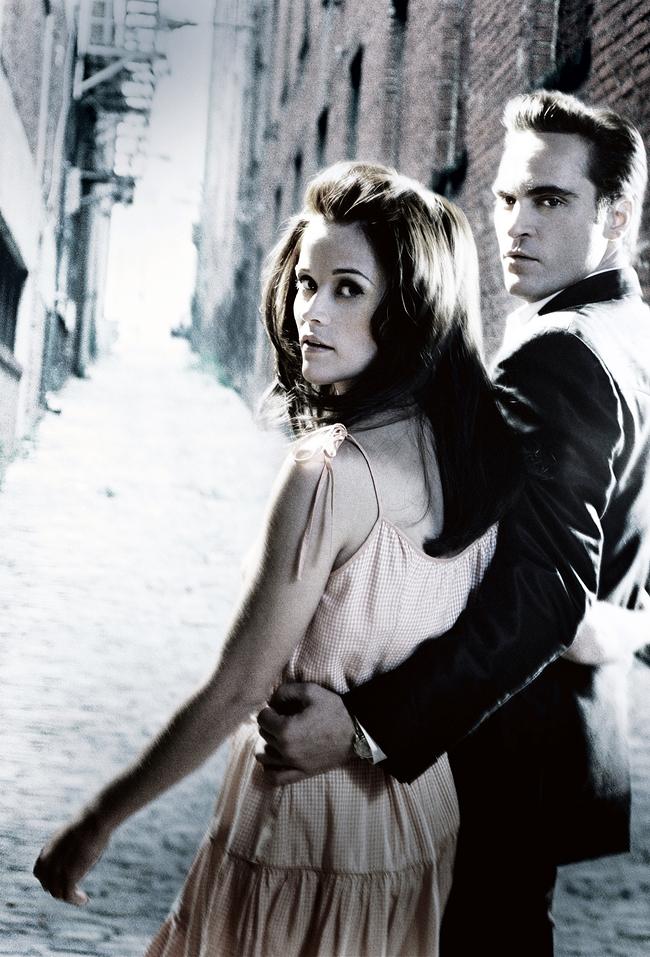 June Carter und Johnny Cash gehen eine schmale Straße entlang und blicken zurück in die Kamera