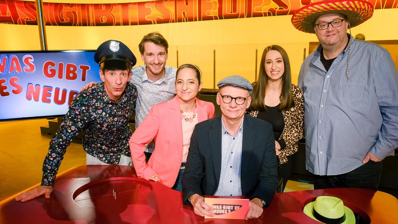 Omar Sarsam mit Polizeikappe, Clemens Maria Schreiner, Caroline Athanasiadis, Lydia Prenner-Kasper, Günther Lainer mit Mexikaner-Hut stehen um Oliver Baier im "Was gibt es Neues?"-Studio 