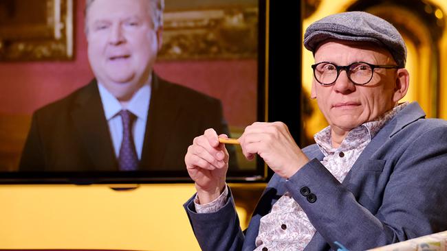 © ORF/Günther Pichlkostner Oliver Baier mit Kappe und Brille sitzt im "Was gibt es Neues?"-Studio vor einem Bildschirm, auf dem Bürgermeister Ludwig zu sehen ist.