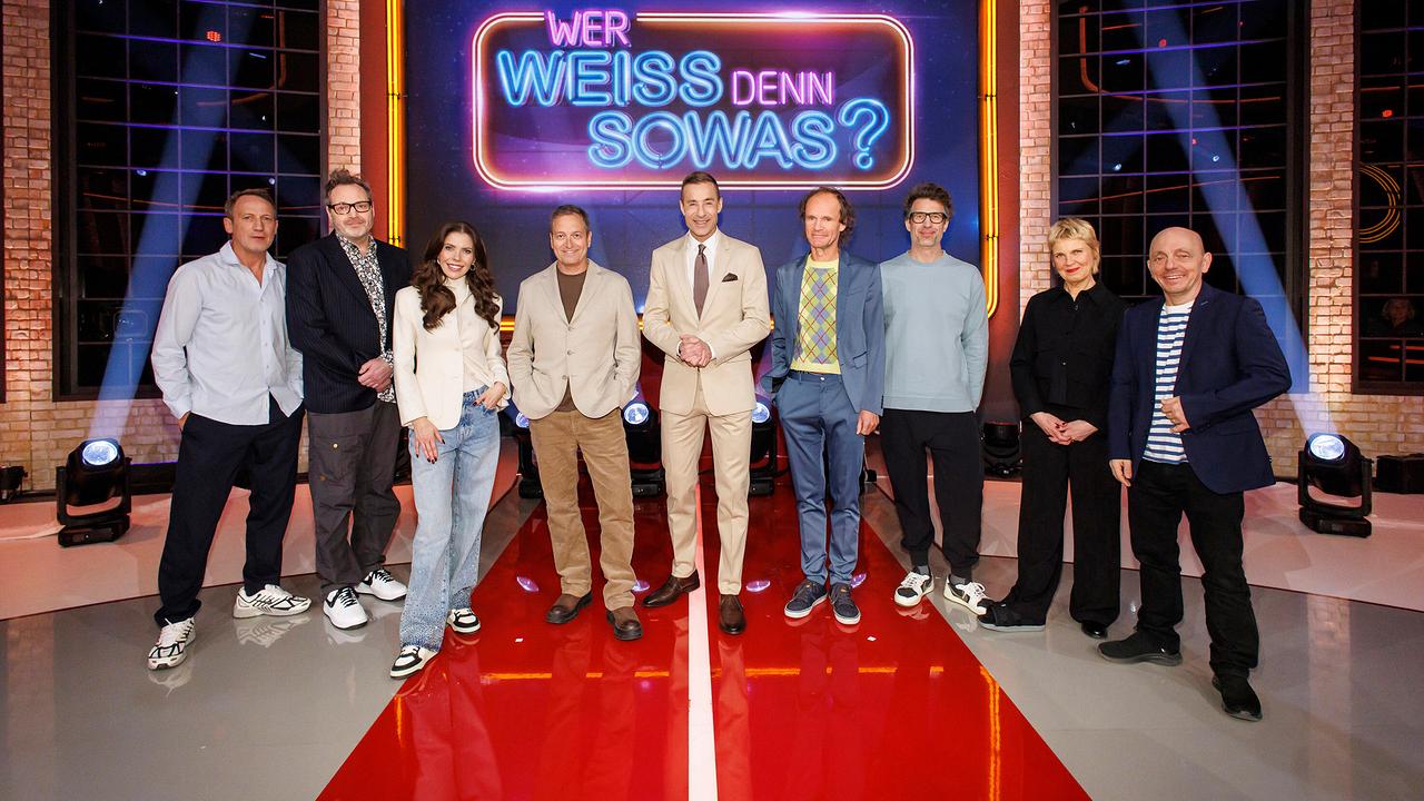 Wotan Wilke Möhring, Paul Panzer, Victoria Swarovski, Dieter Nuhr, Kai Pflaume, Olaf Schubert, Daniel Hartwich, Cordula Stratmann und Bernhard Hoëcker stehen zusammen im Studio vor dem Schriftzug "Wer weiß denn sowas XXL"