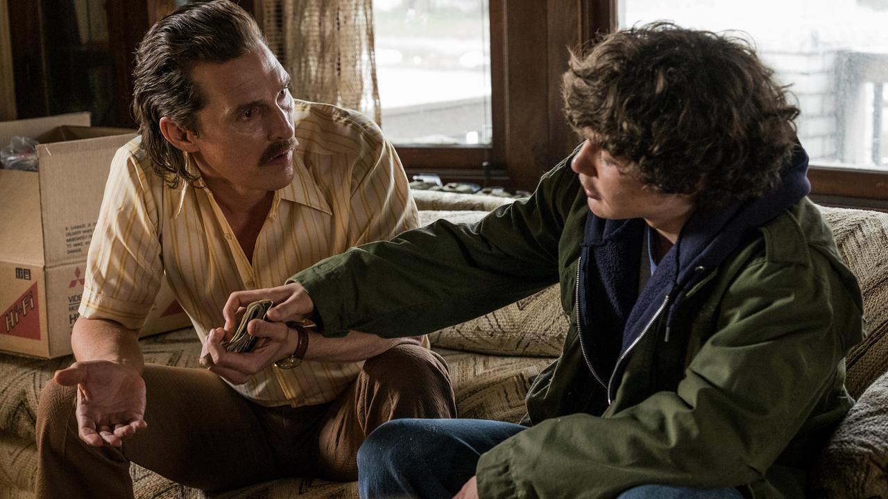 Matthew McConaughey als Vater Richard Wershe und Richie Merritt als dessen Sohn Rick in einem Wohnzimmer, der Vater hat Geldscheine in der Hand, der Sohn greift danach 