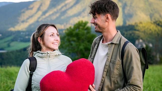 © ORF/TVfriends Single Diego und Kandidatin Sarah lächeln sich am Semmering mit einem herförmigen Polster in den Händen an