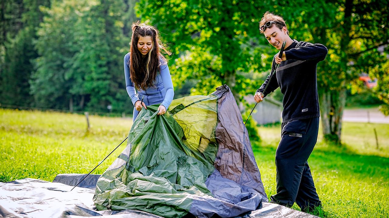 © ORF/TVfriends Kandidatin Isabel und Single Pablo bauen im Beziehungstest ein Zelt auf einer Wiese auf.