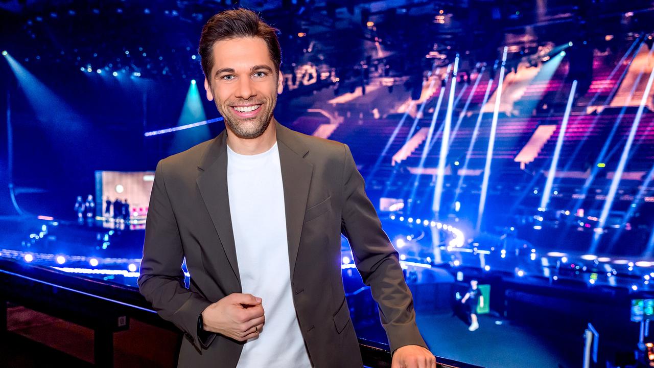 Philipp Maschl steht in der Wiener Stadthalle vor der große ESC-Bühne mit Lichtshow