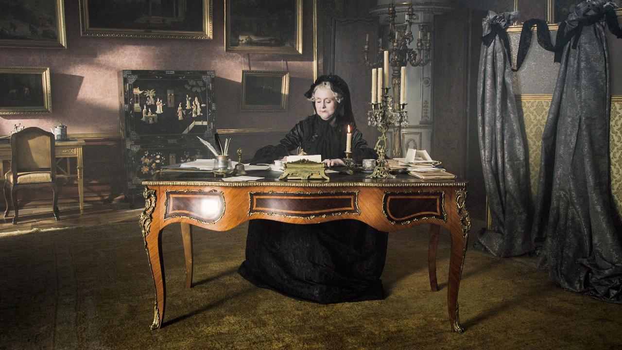 Maria Theresia (Gerti Drassl) sitzt an einem alten Schreibtisch.