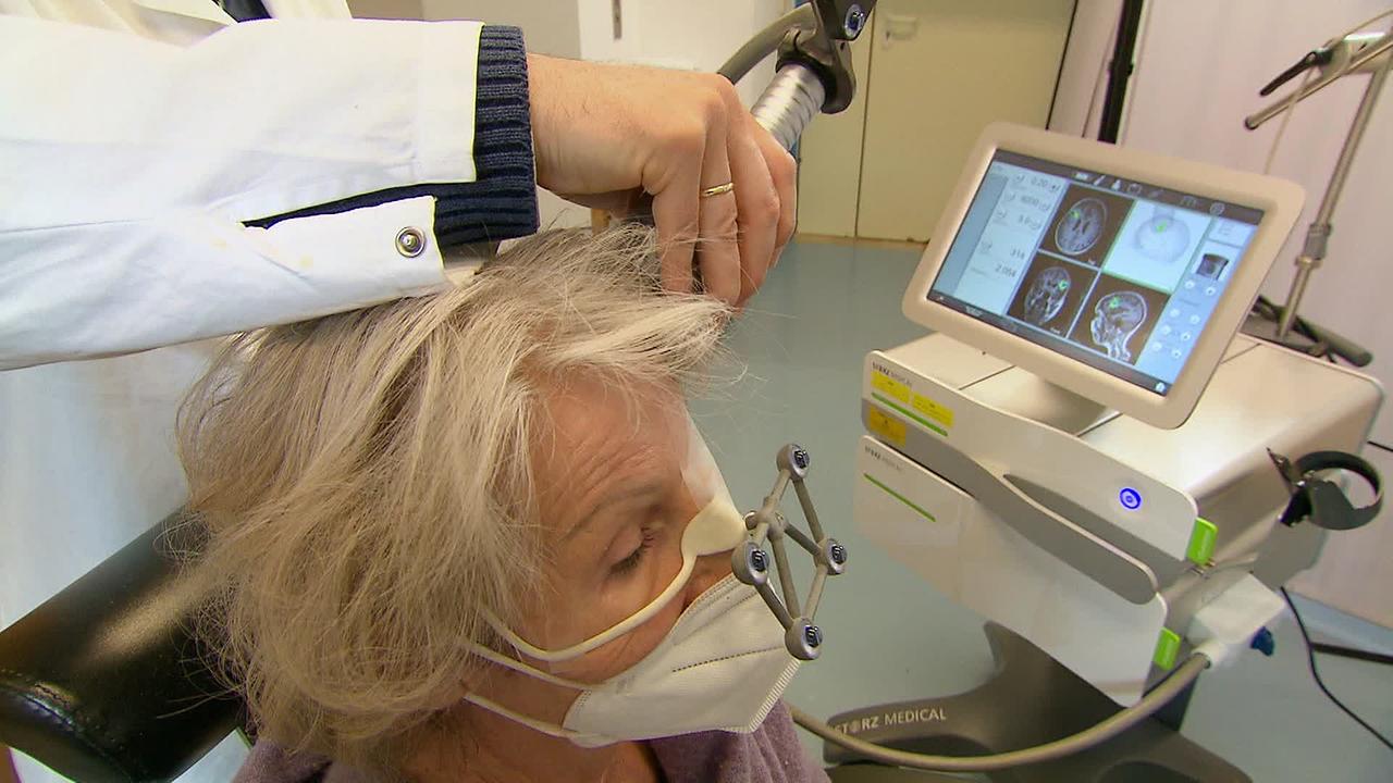 Ältere Dame wird mittels Ultraschall am Kopf behandelt