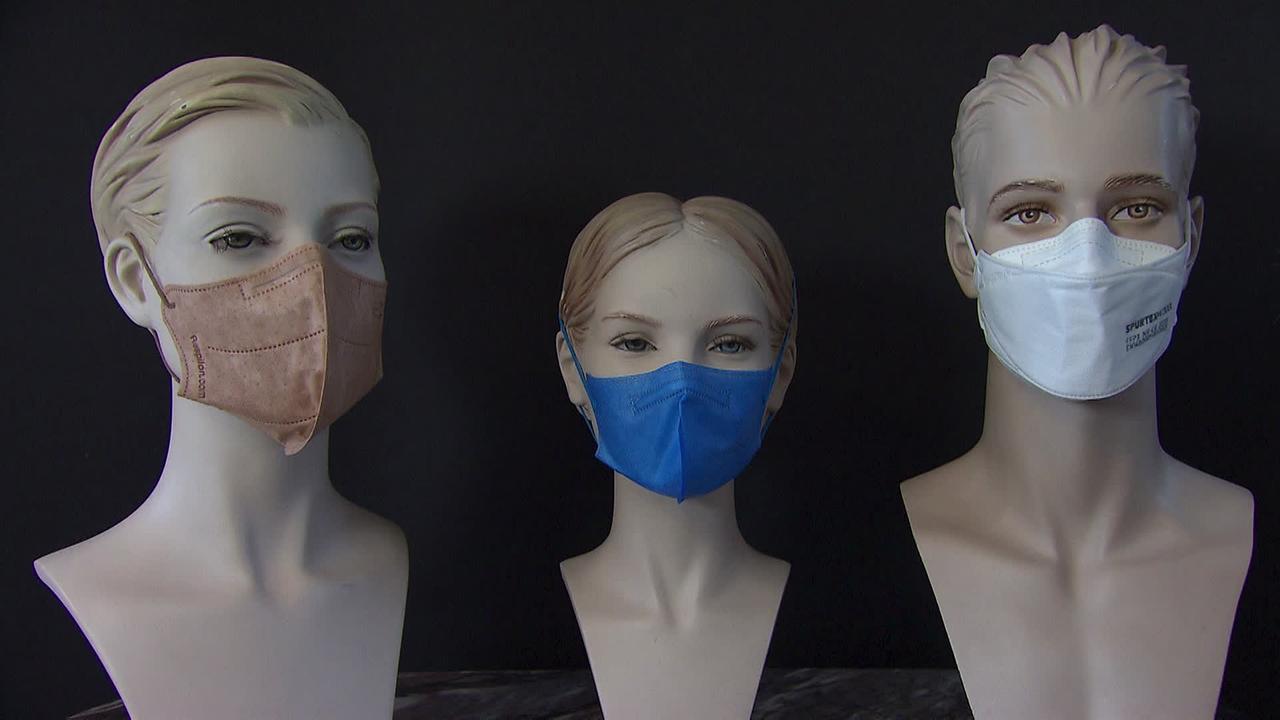 Drei Puppenköpfe, Frau, Mädchen und Mann, die FFP2 Masken tragen.