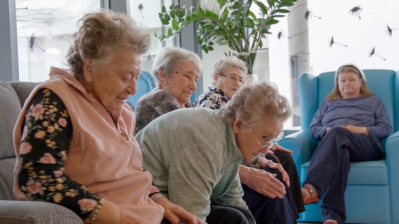 Sitzgymnastik in der in der Seniorenwohngemeinschaft „Demenz(im)Zentrum“. Die Freundinnen Herta Hochwarter und Helene Riedel machen mit Freude mit.