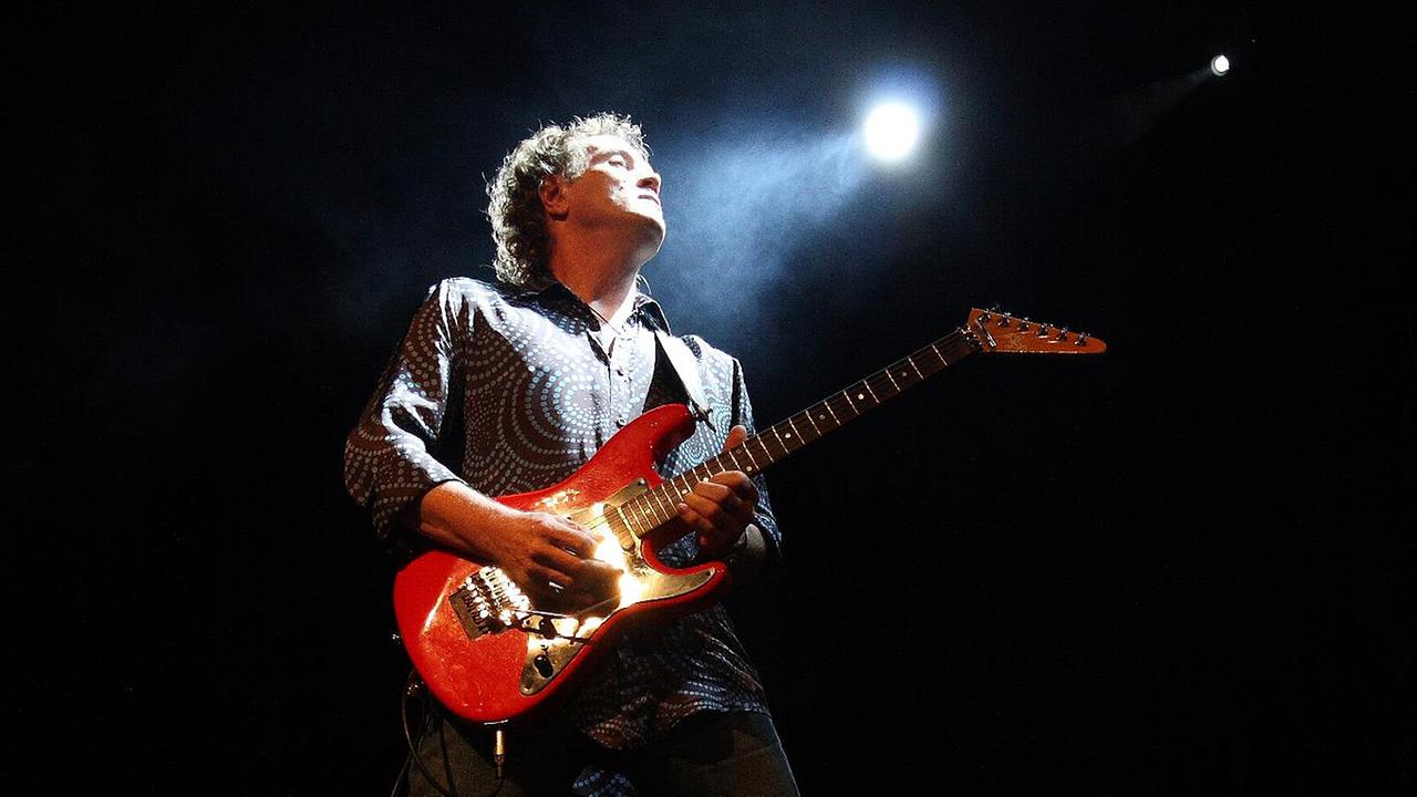 Robby Musenbichler mit Gitarre auf der Bühne im Scheinwerferlicht