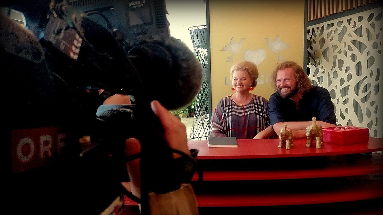 Die Schauspielerin Ulrike Beimpold und der Schauspieler Thomas Stipsits lächeln in die Kamera "Studio 2"- Kamera beim Besuch am Filmset von "Love Machine 2"
