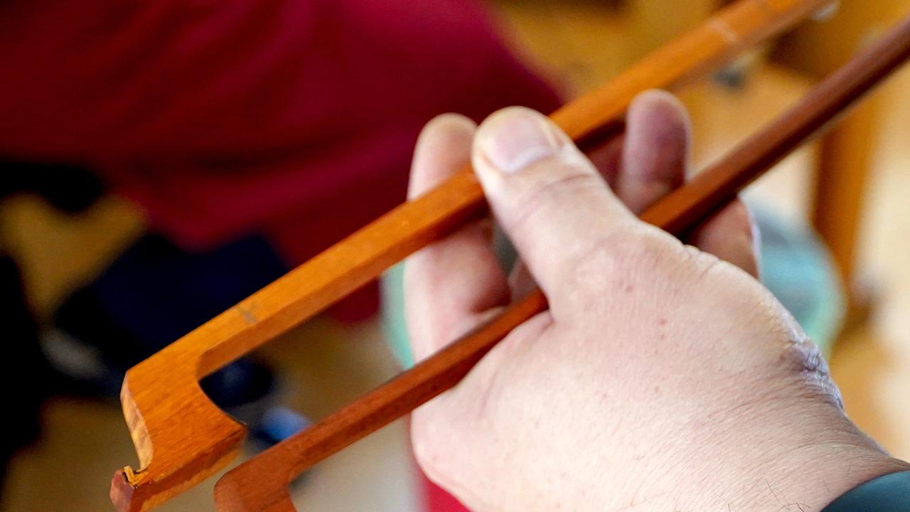 Bogenmacher zeigt Geigenbögen in unterschiedlichen Fertigungsstadien