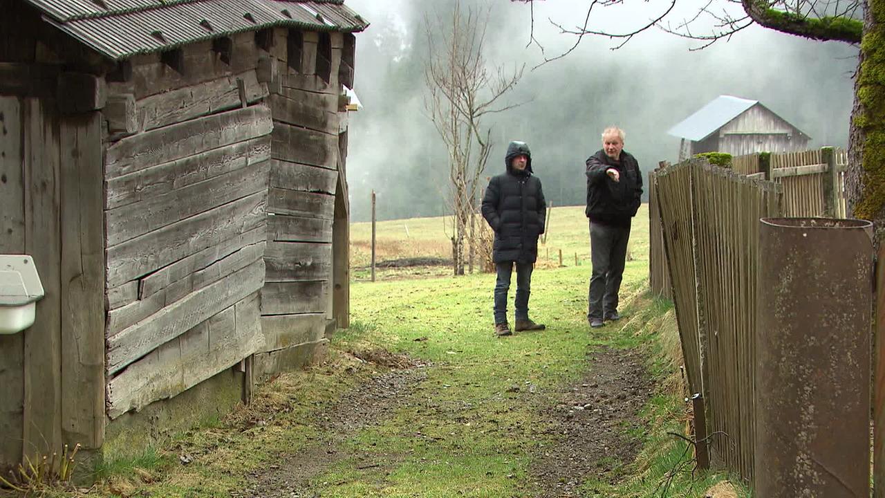Reporter Christoph Seibel und Herr W. auf seinem Wiesenweg neben einem Holzzaun. 