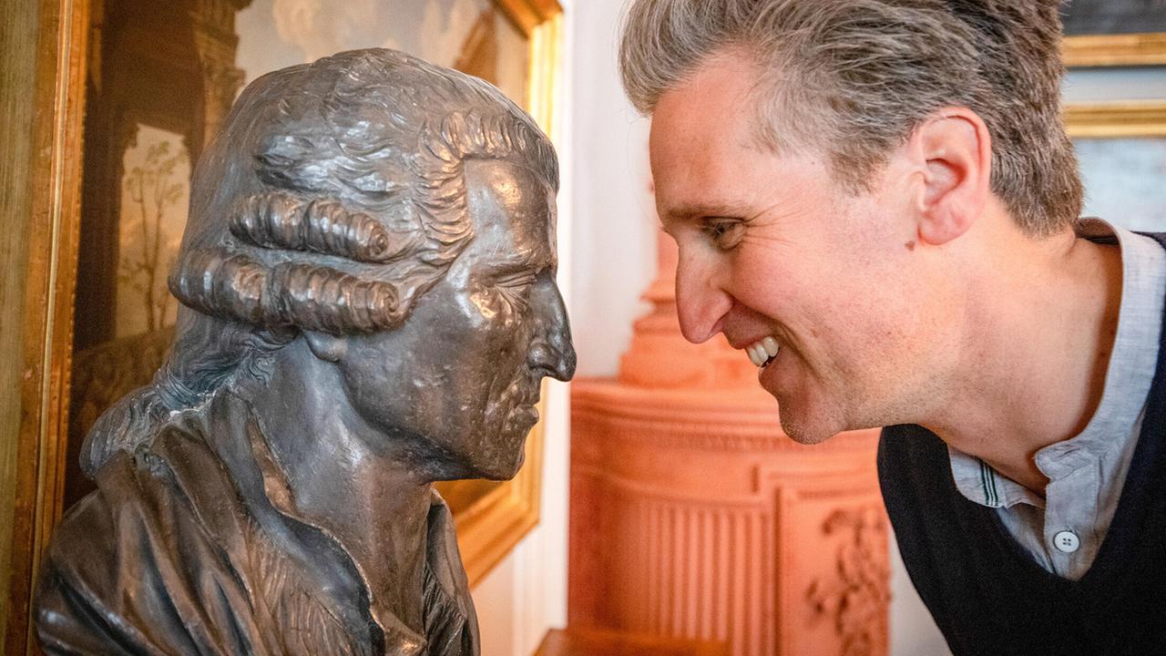 "Herrschaftszeiten! - Johann-Philipps Schlossbesuche": Johann-Philipp Spiegelfeld vor einer Haydn Büste in Schloss Rohrau