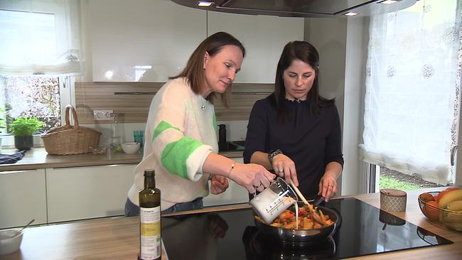 zwei Frauen bereiten in der Küche eine Mahlzeit zu
