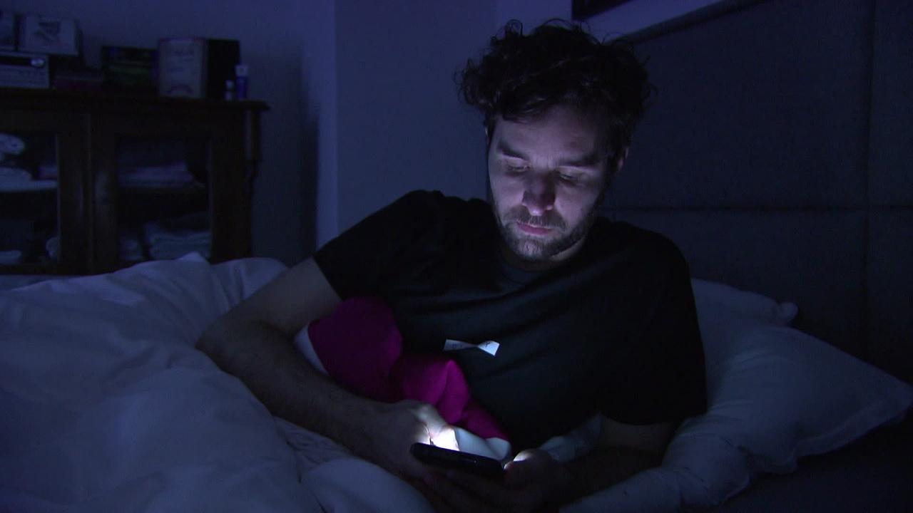 Mann im Bett am Handy