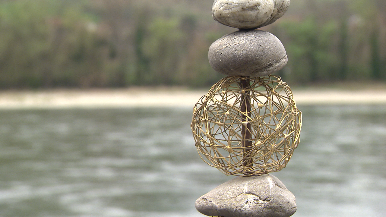 Kunstwerk aus Steinen im Vordergrund, Donau im Hintergrund
