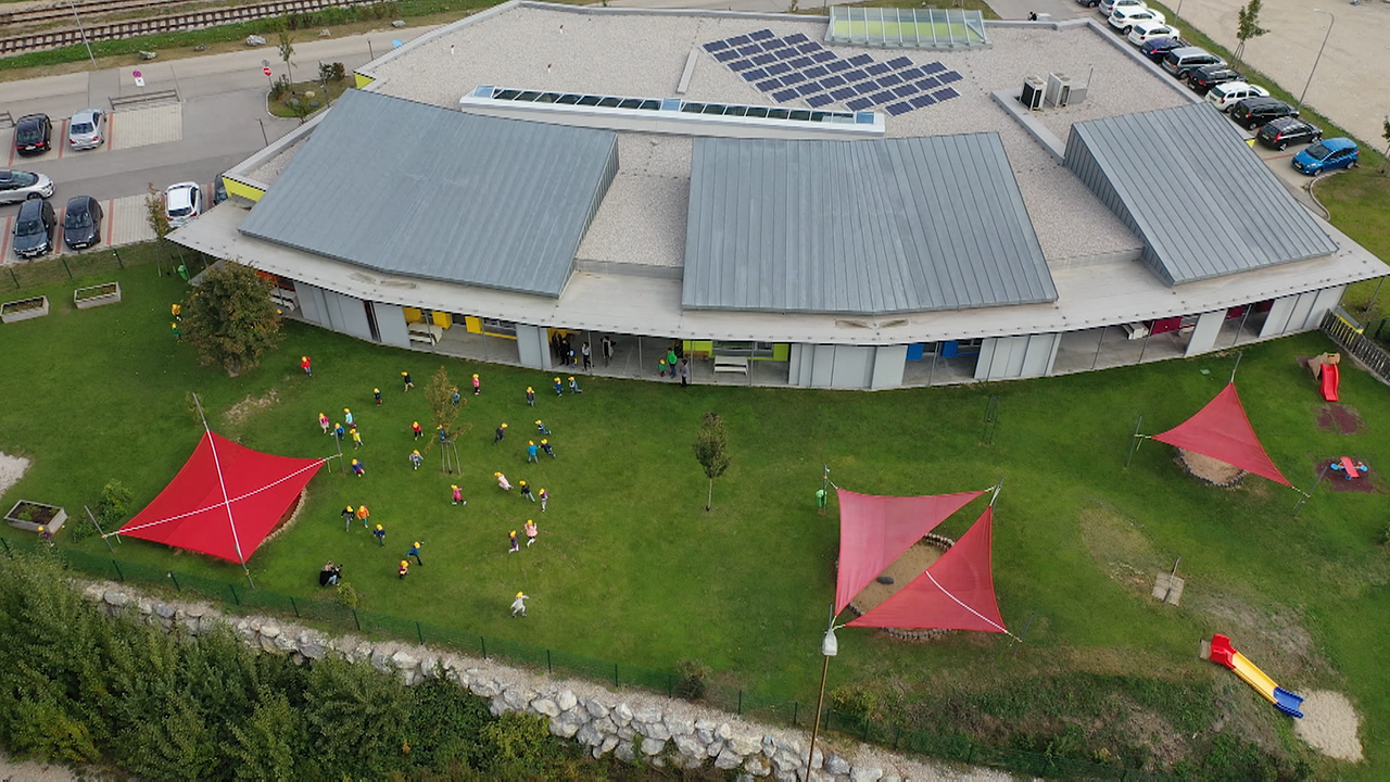 Betriebsgebäude von oben mit spielenden Kindern im Garten