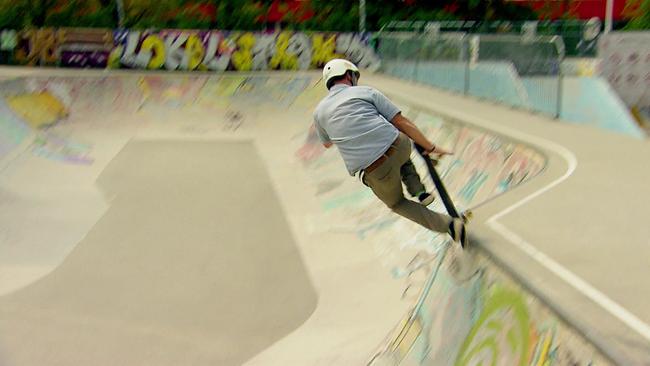 Skateboard fahrender Mann in einem Skatepark