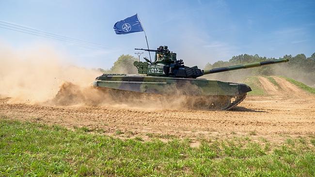 ein fahrender Panzer mit NATO-Fahne