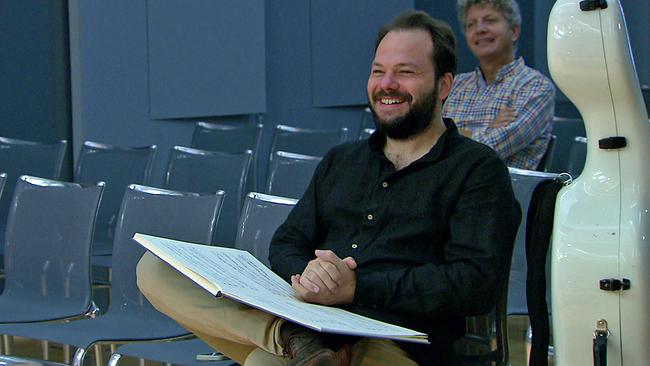 © ORF Petr Popelka lachend, Hände auf Partitur