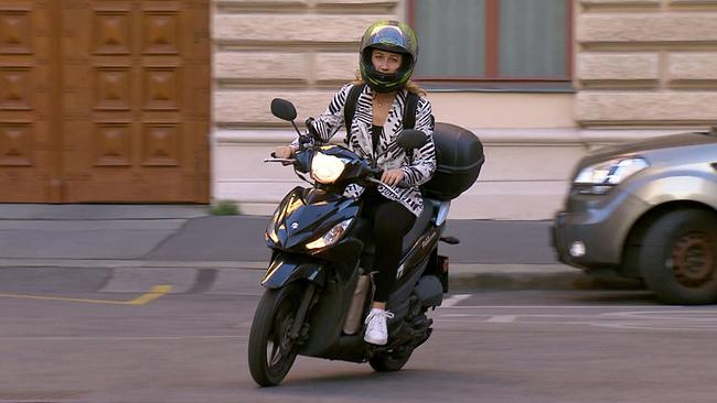 © ORF Andrea Götsch mit Helm auf Zweirad auf Straße
