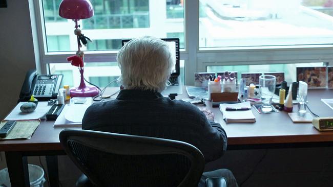 John Irving von hinten am Schreibtisch sitzend