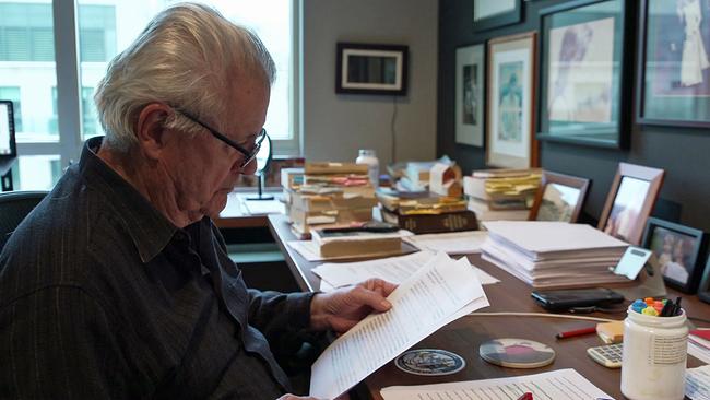 John Irvingam Schreibtisch Manuskript lesend