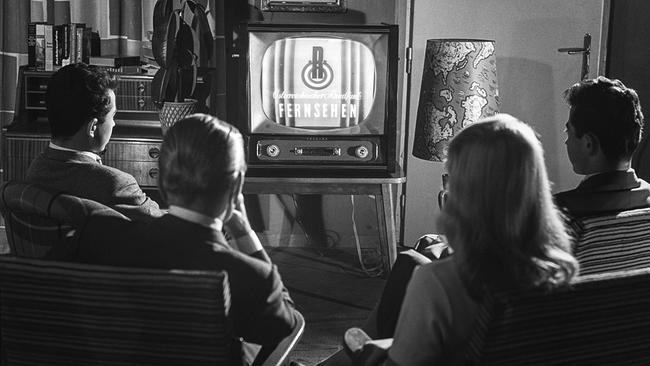 Schwarzweissbild: Menschen sitzen vor TV-Gerät