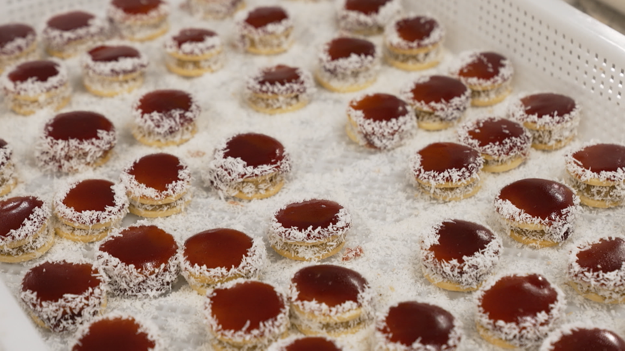 Kekse mit roter Marmelade und Kokosflocken am Rand