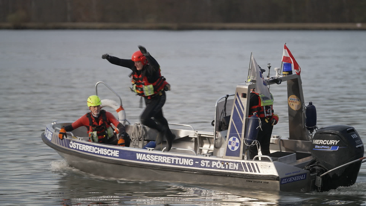 Ein Mitglied der Wasserrettung springt vom Boot ins Wasser.