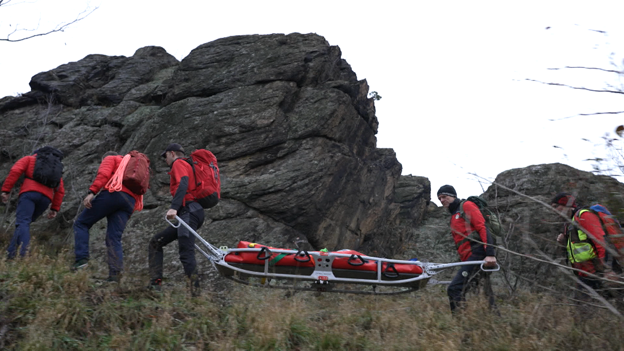 Die Bergrettung transportiert eine Trage in felsigem Gelände