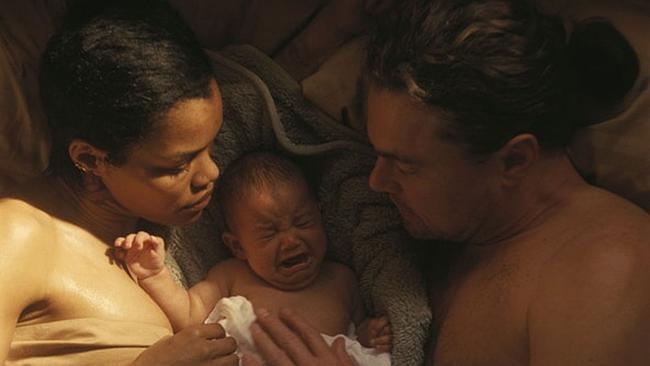 Filmstill "One Battle After Another" - Frau und Mann liegend mit Baby in der Mitte