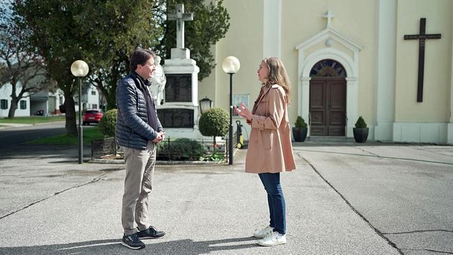 Martin Traxl interviewt vor betoniertem Kirchenplatz Initiatorin "Baba Beton"
