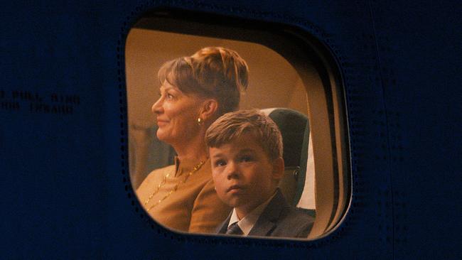 Filmstill „Propeller One-Way Night Coach“ / Frau und Bub blickt aus Flugzeugfenster