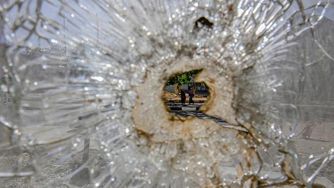 Blick durch Einschussloch in zersplitterndem Glas: Sudanesische Frauen auf der Straße