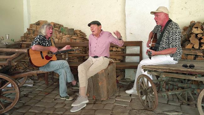 Wolfgang Ambros singend, begleitet von 2 Gitarristen