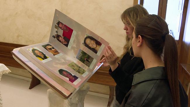 L' Aquila Frauen blättern in Gedenkbuch mit Fotos der Erdbebenopfer