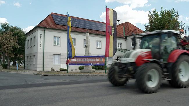 © ORF Traktor fährt an Plakat Pulkautal Biennale vorbei