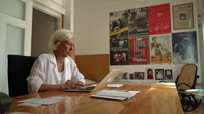 Käthe Kratz  am Laptop im Hintergrund Plakate ihrer Filme