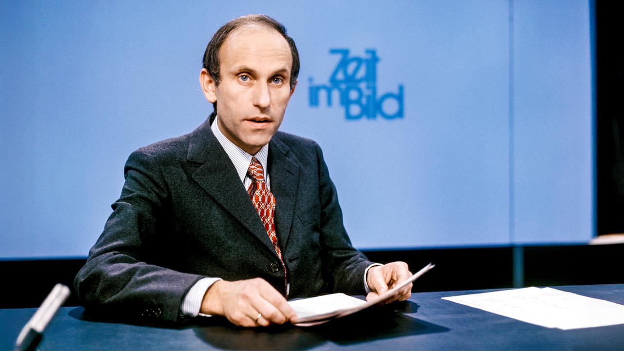 Franz Kreuzer moderiert die "Zeit im Bild" (1972): er sitzt am Schreibtisch vor dem „Zeit im Bild“-Logo und hält ein Skript in der Hand.