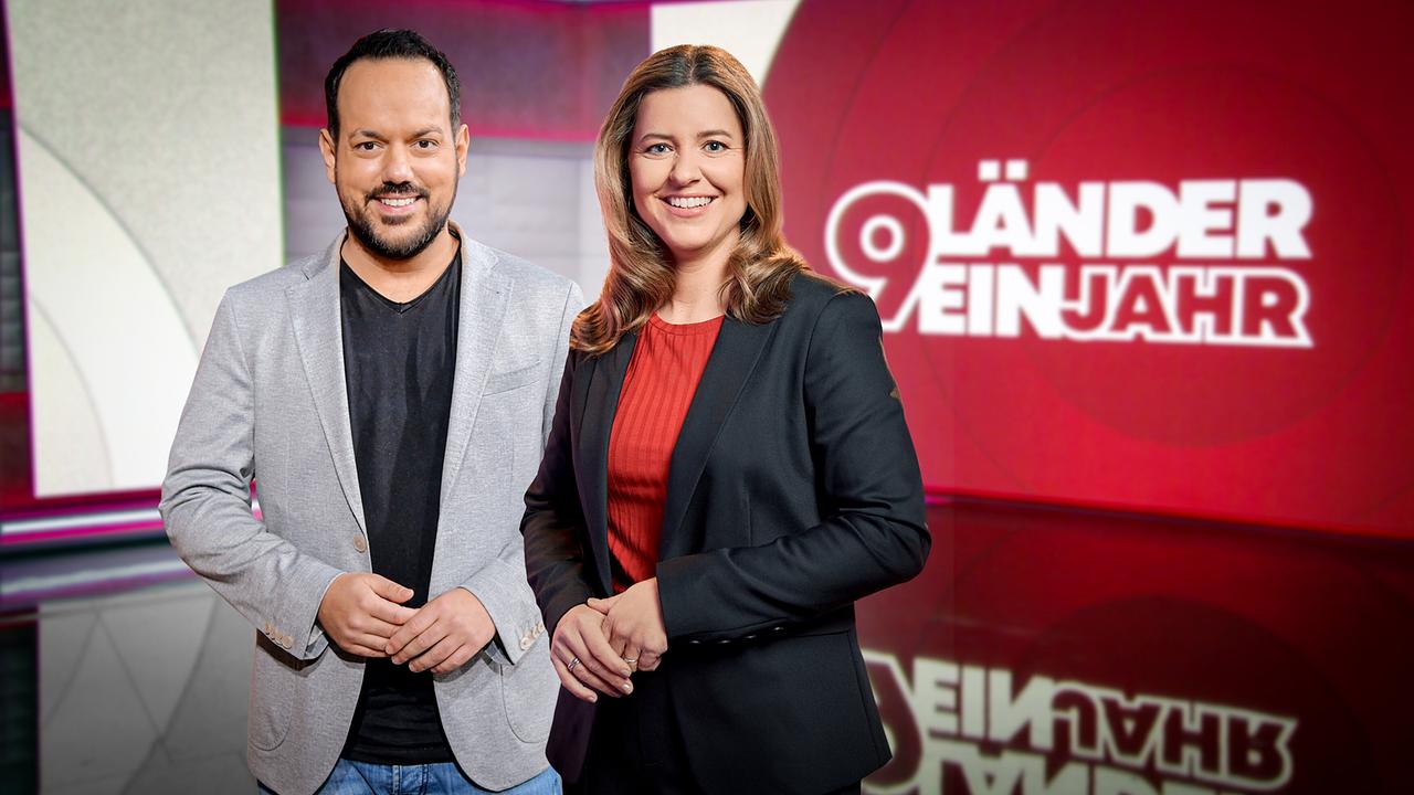 Das Moderatorenteam Patrick Budgen und Christiane Schwald-Pösel im Studio mit Schriftzug "9 Länder - ein Jahr" im Hintergrund