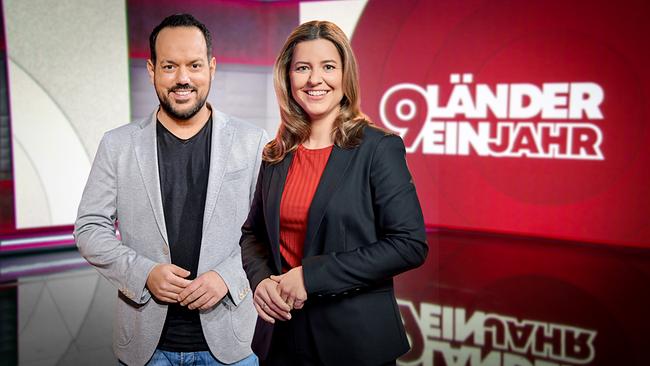 Das Moderatorenteam Patrick Budgen und Christiane Schwald-Pösel im Studio mit Schriftzug "9 Länder - ein Jahr" im Hintergrund