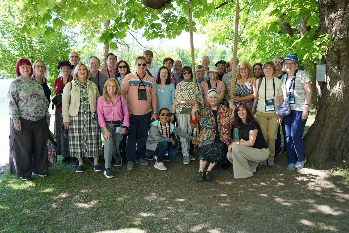 Angela Cartwright, Schauspielerin aus dem FIlm, mit einer amerikanischen Reisegruppe, die alle große Fans von The Sound of Music sind, im Garten von Schloss Leopoldskron