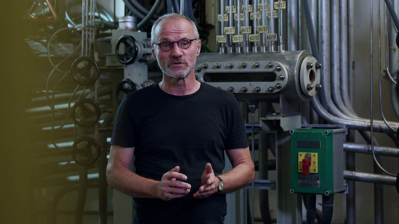 Stefan Zach steht in einem Technikraum des stillgelegten Atomkraftwerks Zwentendorf vor Rohren und Armaturen.