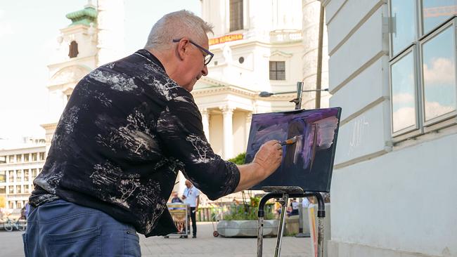 Der weißrussische Maler Jerzy Glebowicz an seinem Arbeitsplatz vor der Wiener Karlskirche