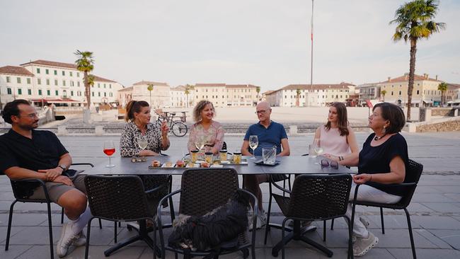 Mark Richter, Barbara Karlich, NIcole Richter und ihr Lebensgefährte Andrea Bolzicco und Gloria und Katharina Karlich im Gespräch, sie sitzen an einem Tisch am Hauptplatz von Palmanova 