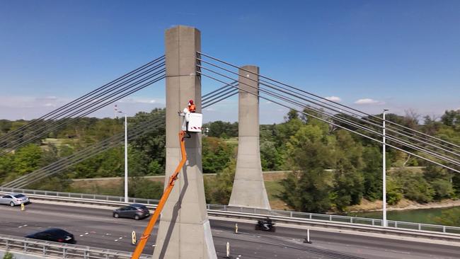 © ORF zwei Arbeiter in einem Krankorb arbeiten an einem Stützpfeiler einer Straßenbrücke