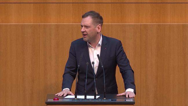 © ORF Philipp Kucher bei einer Ansprache im Parlament, vor ihm ein Pult mit Mikrofonen, hinter ihm Holzwände