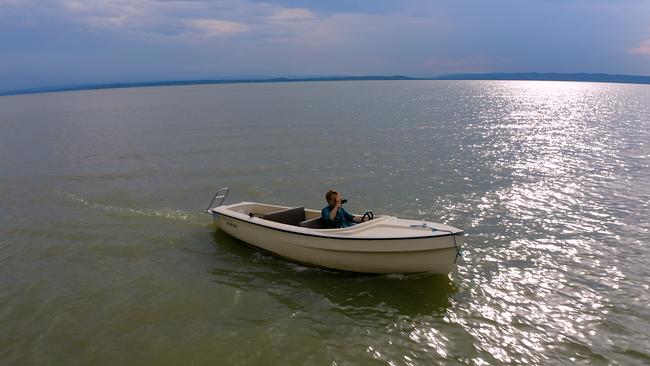 Max Müller fährt in einem kleinen Boot am Neusiedler See