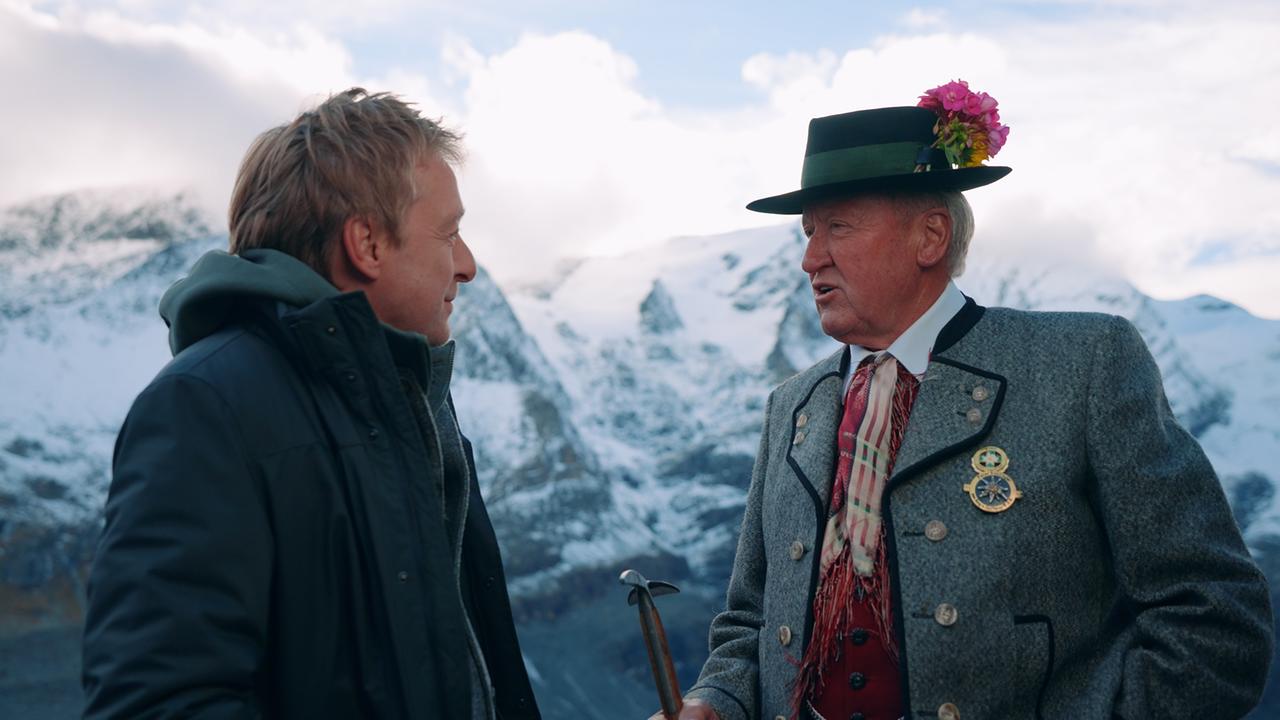 Max Müller im Gespräch mit Bergführer Peter Suntinger vor Bergkulisse